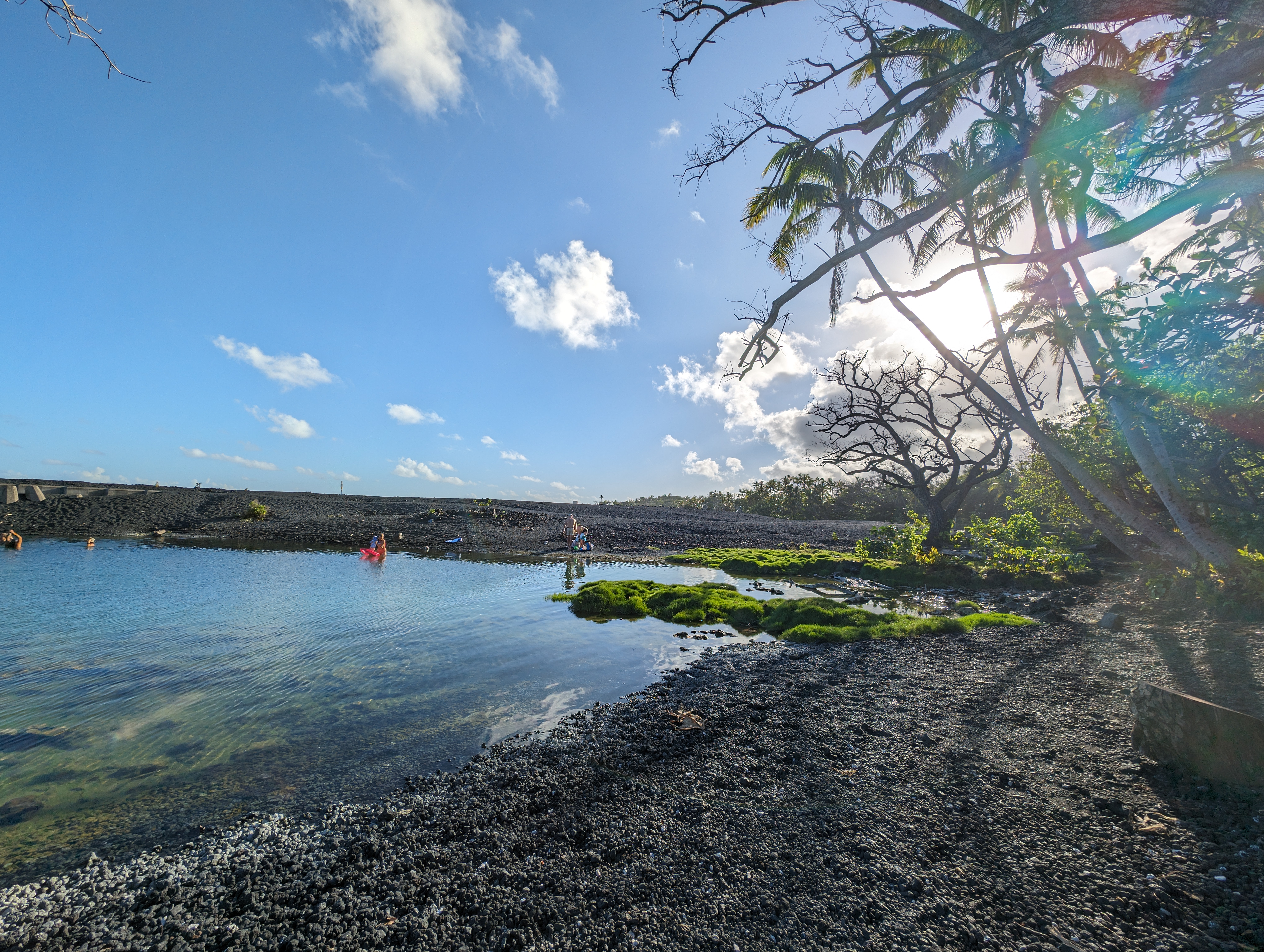 Sunny ocean hot spring, black sand and moss